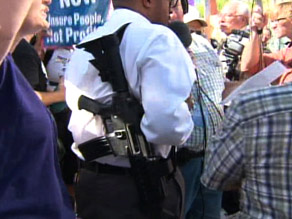 A man is shown legally carrying a rifle at a protest against President Obama on Monday in Phoenix, Arizona (Photo Credit CNN News)
