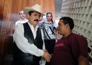 Honduran ousted President Manuel Zelaya (L), shakes hands with a supporter