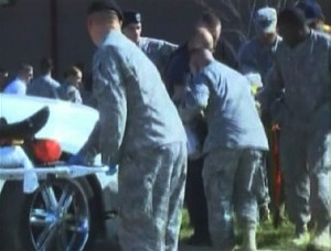 This image, made from a defense dept. video, shows emergency personnel taking a wounded person on a stretcher to an awaiting ambulance at the scene at the U.S. Army base in Fort Hood, Texas.