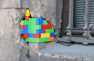 Lego blocks fill in a crack in building that lost tile  as part of artist Jan Vormann's 