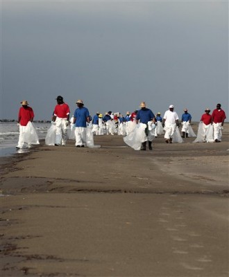 Workers walk along the beach as they clean up oil residue in Grand Isle, La., Sunday, May 30, 2010. With BP declaring failure in its latest attempt to plug the uncontrolled gusher feeding the worst oil spill in U.S. history, the company is turning to yet another mix of risky undersea robot maneuvers and longshot odds to keep crude from flowing into the Gulf. Six weeks after the catastrophe began, oil giant BP PLC is still casting about for at least a temporary fix to the spewing well underneath the Gulf of Mexico that's fouling beaches, wildlife and marshland. A relief well that's currently being drilled, which is supposed to be a better long-term solution, won't be done for at least two months. That would be in the middle of the Atlantic hurricane season, which begins Tuesday. (AP Photo/Jae C. Hong)
