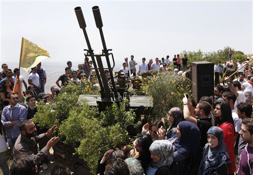 Lebanese university students, gather around an anti-aircraft gun as a Hezbollah fighter explain to them the group's various tactics and weapons used against Israeli soldiers on the battlefield, during a trip to Hezbollah strongholds, in Sojod village, southern Lebanon, on Saturday, May 22, 2010. With a sprawling war museum of its history and student tours to its strongholds, Hezbollah is promoting itself through "jihadi tourism" to mark the 10th anniversary of Israel's withdrawal from southern Lebanon. It's a way to showcase its military prowess at a time when Israel and the U.S. say Iranian-backed group is acquiring more sophisticated weaponry. (AP Photo/Hussein Malla)