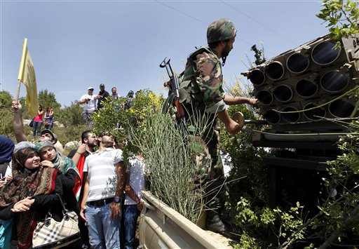 Lebanese university students look at a Hezbollah fighter as he stand behind an empty rocket launcher while explaining to the group various tactics and weapons used against Israeli soldiers on the battlefield, during a trip to Hezbollah strongholds, in Sojod village, southern Lebanon, on Saturday, May 22, 2010. With a sprawling war museum of its history and student tours to its strongholds, Hezbollah is promoting itself through "jihadi tourism" to mark the 10th anniversary of Israel's withdrawal from southern Lebanon. It's a way to showcase its military prowess at a time when Israel and the U.S. say Iranian-backed group is acquiring more sophisticated weaponry.(AP Photo/Hussein Malla)