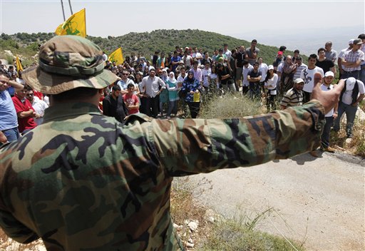  A Hezbollah fighter, explains to Lebanese university students the group's various tactics and weapons used against Israeli soldiers on the battlefield, during a trip to Hezbollah strongholds, in Sojod village, southern Lebanon, on Saturday May 22, 2010. With a sprawling war museum of its history and student tours to its strongholds, Hezbollah is promoting itself through "jihadi tourism" to mark the 10th anniversary of Israel's withdrawal from southern Lebanon. (AP Photo/Hussein Malla)