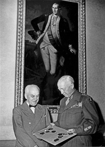 This image provided by The Huntington Library, Art Collections, and Botanical Gardens shows Gen. George S. Patton Jr., right, presenting Huntington trustee Robert Millikan with an original 1935 typescript of the Nuremberg Laws signed by Adolf Hitler, on June 11, 1945. During the final days of World War II, as American soldiers were returning home from Germany with helmets, swastika-inscribed flags and other Nazi memorabilia, Gen. George Patton was packing up his own sourvenirs, including four pages of these documents signed by Adolf Hitler that set up the legal framework for the Nazis to kill six million Jews.   (AP Photo/The Huntington Library, Art Collections, and Botanical Gardens)
