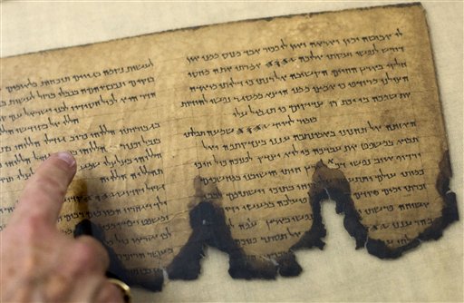 A worker of the IAA, Israel Antiquities Authority, points at a fragment of the Dead Sea Scrolls in a laboratory in Jerusalem, Tuesday, Oct. 19, 2010. Israel's Antiquities Authority and Google announced Tuesday they are joining forces to bring the Dead Sea Scrolls online, allowing both scholars and the general public widespread access to the ancient manuscripts for the first time. (AP Photo/Sebastian Scheiner)