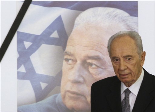 Israeli President Shimon Peres walks past a picture of late Israeli Prime Minister Yitzhak Rabin, during a memorial ceremony marking the 15th anniversary of his assassination, at the President's residence in Jerusalem, Tuesday, Oct. 19, 2010. Israel on Tuesday started marking the 15th anniversary of Rabin's assassination, according to the Jewish calendar. The late Israeli Prime Minister was killed by a Jewish extremist on November 4, 1995, after attending a peace rally. (AP Photo/Tara Todras-Whitehill)