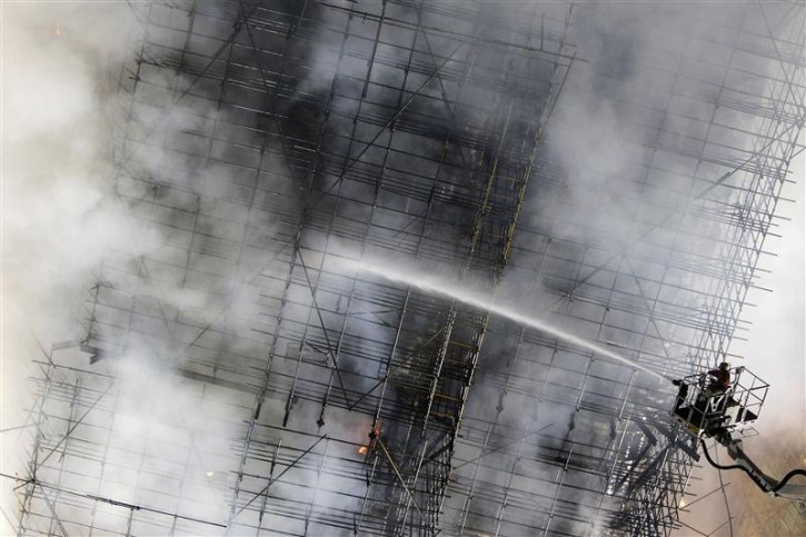 Firefighters try to extinguish a fire at a building in Shanghai, November 15, 2010.