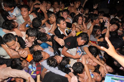 A crowd of Cambodians are pushed onto a bridge on the last day of celebrations of a water festival in Phnom Penh, Cambodia, Monday, Nov. 22, 2010. Thousands of people celebrating a water festival on a small island in a Cambodian river stampeded Monday evening, killing at least 17 people, a hospital official said. Hundreds more were hurt as the crowd panicked and pushed over a bridge to the mainland. (AP Photo/Heng Sinith)