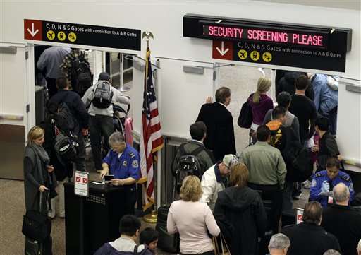 TSA agents check passenger identification at a security gate, Friday, Nov. 19, 2010, at Seattle-Tacoma International Airport in Seattle. (AP Photo/Ted S. Warren)