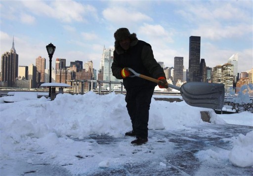 A Parks Department employee clears away snow at the Gantry Plaza State Park in New York January 12, 2011. REUTERS/Shannon Stapleton 