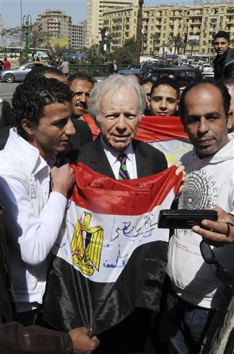 Egyptians hold their national flag as they have their photo taken with U.S. senator Joseph Lieberman, I-CT, center, during his visit to Tahrir Square, the focal point of the Egyptian uprising, in Cairo, Egypt, Sunday, Feb. 27, 2011. (AP Photo/Mohammed Ismail)