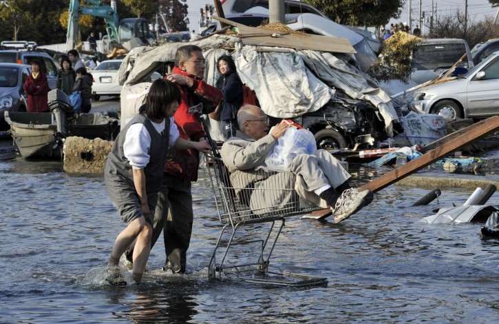 Two residents push an elderly man in a supermarket trolley through water brought by tsunamis in the devastated main street  in Ishinomaki, Miyagi Prefecture, northern Japan, about 270km north of Tokyo,13 March, 2011 after strong earthquakes and tsunami killing more than 1,000 people were hitting northern Japan and Japanese capital of Tokyo area on 11 March.  EPA/KIMIMASA MAYAMA
