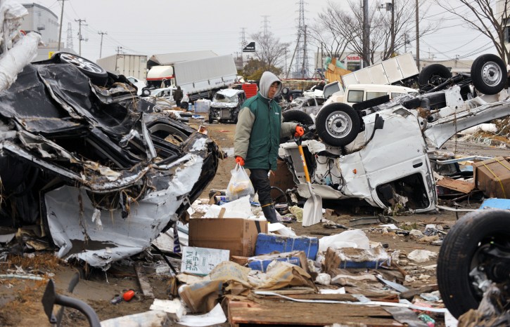 A resident walks between overturned vehicles as he heads for his parents' home in tsunami-devastated city of Tagajo, Miyagi Prefecture, northern Japan, about 220km north of Tokyo,13 March, 2011. Strong earthquakes and tsunamis  hit  northern Japan and Japanese capital of Tokyo area on 11 March. Japanese police say that the number of people killed in the disaster could surpass 10,000  EPA/KIMIMASA MAYAMA