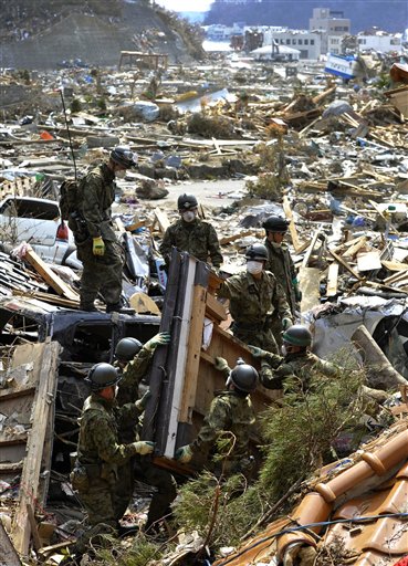 Japan's Self-Defense Force's members remove debris as they search for missing persons in the March 11 earthquake and tsunami-destroyed town of Onagawa, northern Japan Friday, March 25, 2011. (AP Photo/Kyodo News)