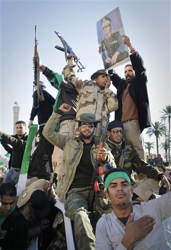 Pro-Gadhafi soldiers and supporters gather to celebrate in Green Square, Tripoli, Libya Sunday, March 6, 2011. Thousands of Moammar Gadhafi's supporters poured into the streets of Tripoli on Sunday morning, waving flags and firing their guns in the air in the Libyan leader's main stronghold, claiming overnight military successes. (AP Photo/Ben Curtis)