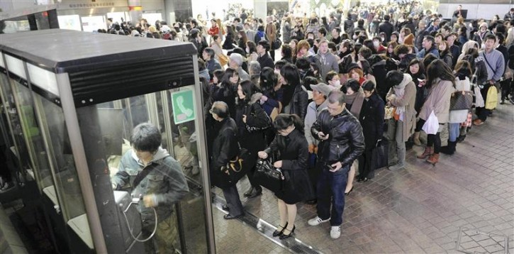 People line up in front of public telephone booths at Shibuya station in Tokyo March 11, 2011. The biggest earthquake to hit Japan since records began 140 years ago struck the northeast coast on Friday, triggering a 10-metre tsunami that swept away everything in its path, including houses, ships, cars and farm buildings on fire.   REUTERS/YOMIURI