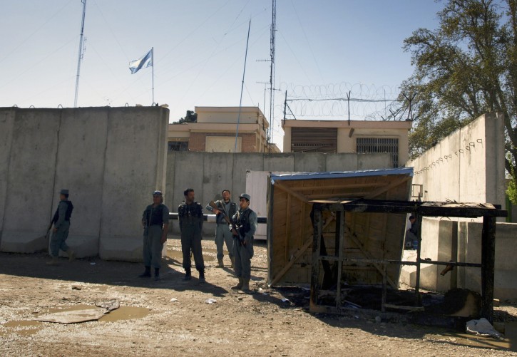 Afghan policemen stand guard near a burnt booth, right, at the compound of UN's office, which was attacked by protesters on Friday during a demonstration to condemn the burning of a copy of the Muslim holy book by a U.S. Florida pastor, in Mazar-i- Sharif north of Kabul, Afghanistan on Saturday, April. 2, 2011. Afghans angry over the burning of a Quran at a small Florida church stormed a U.N. compound in northern Afghanistan on Friday, killing seven foreigners, including four Nepalese guards. (AP Photo/Mustafa Najafizada)