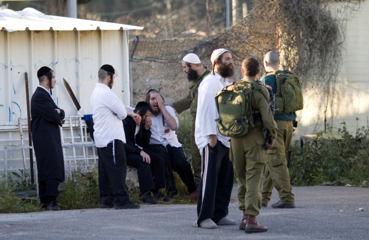Jewish worshippers react moments after they arrived to at an entrance to a military base near the West Bank city of Nablus,  Sunday, April 24, 2011. Palestinians shot and killed one Israeli and wounded two others early Sunday near Joseph's Tomb, a Jewish holy site inside the Palestinian city of Nablus, the Israeli military and rescue services said. (AP Photo/Ariel Schalit)