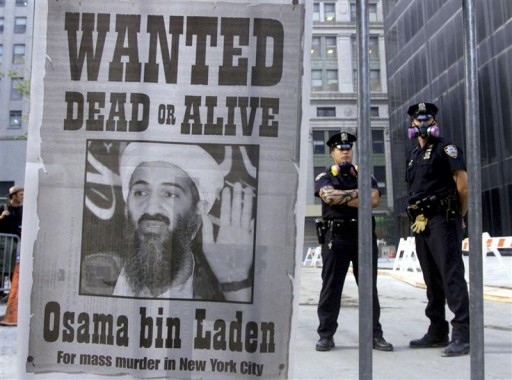 Police stand near a wanted poster of Saudi-born militant Osama bin Laden, printed by a New York newspaper, in New York in this September 18, 2001 file photograph.
