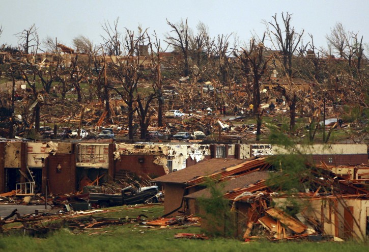 Rescuers and neighbors look through the the wreckage of destroyed homes on a hillside in Joplin, Mo., Sunday, May 22, 2011. A large tornado moved through much of the city, damaging a hospital and hundreds of homes and businesses. (AP Photo/Mark Schiefelbein)