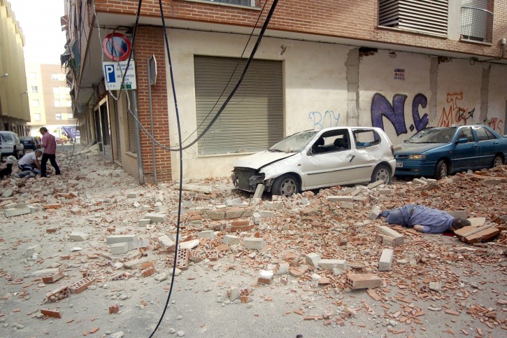 Two men try to help a victim (L) while another body (R) lies among the rubble at the Galicia street in Lorca, southern Spain, after an earthquake measuring 5.3 hit the town on 11 May 2011 causing houses to collapse, damaging historic churches and killing at least 10 people.  EPA/ISRAEL SANCHEZ