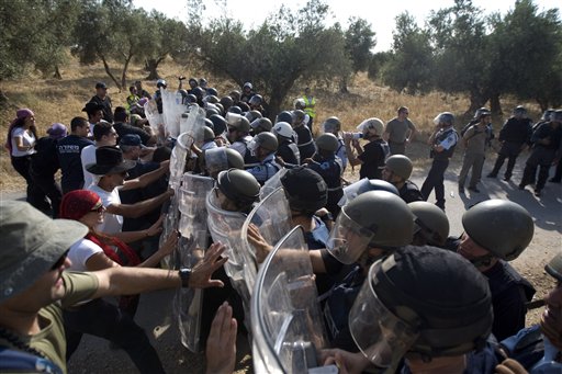 FILE - Israeli police officers dressed as Arab protesters push Israeli riot police officers during a training simulating riots, Tuesday, June 14, 2011 in Hadid forest , central Israel. Concerned about possible riots linked to a unilateral statehood declaration by the Palestinians in September.  (AP Photo/Ariel Schalit)