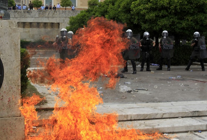 Demonstrators throws a petrol bomb to riot police at Syntagma square in front of the Greek Parliament in central Athens, during a rally against plans for new austerity measures, on Wednesday, June 15, 2011. A 24-hour strike by Greece's largest labor unions is set to cripple public services Wednesday, as the Socialist government begins a legislative battle to push through last-ditch cost cutting reforms that will exceed its own term in office.Demonstrators had camped outside parliament since May 25, 2011.  (AP Photo/Thanassis Stavrakis)