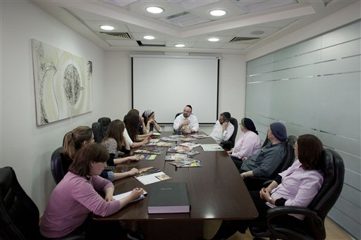 In this photo taken Monday June 27, 2011, staff of the English edition of the weekly newspaper "Mishpacha" gather during a meeting at the Mishpacha office in Jerusalem. The community of ultra-Orthodox Jews in Israel, long an insular island where rabbis ruled and the outside world was viewed with suspicion or ignored altogether, is being quietly and profoundly altered by a proliferation of new media outlets shining a light on topics that were long taboo. (AP Photo/Bernat Armangue)