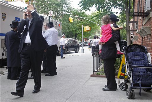 State Assemblyman Dov Hikind, left, talks on a phone as he arrives at the apartment where Leiby Kletzky lived with his family in the Brooklyn borough of New York, Wednesday, July 13, 2011.  (AP Photo/Bebeto Matthews)