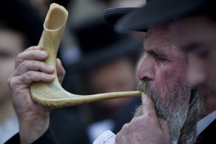 An ultra-Orthodox Jew blows the shofar, a ram's horn, while attending a prayer and protest against the celebration of summer festivals in the city of Jerusalem, Monday, Aug. 11, 2011. The protest was held in the Mea Shearim neighborhood of Jerusalem. (AP Photo/Bernat Armangue)