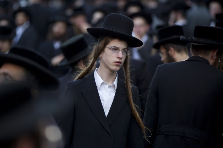 An Ultra-Orthodox Jew attends a prayer as he and others gather in the religious neighborhood of Mea Shearim to protest against summer events organized by the city council, Jerusalem, Thursday, Aug. 11, 2011. (AP Photo/Bernat Armangue)