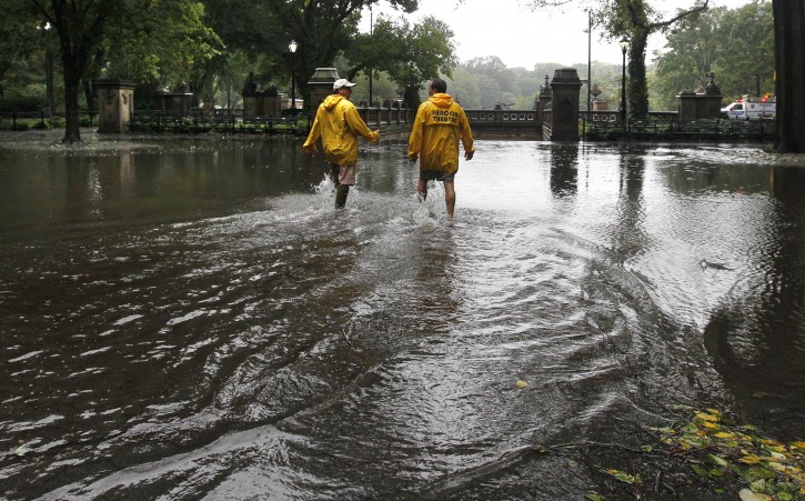 David Korostoff, left, and Jimmy Kaplow, both of New York, step through standing water on a walkway in New York's Central Park as Tropical Storm Irene passes through the city, Sunday, Aug. 28, 2011. Although downgraded from a hurricane to a tropical storm, Irene's torrential rain coupled with high winds and tides worked in concert to flood parts of the city. (AP Photo/Elise Amendola)