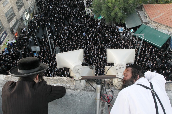 orthodox Jews watch from a rooftop as hundreds of ultra orthodox jews protest in the orthodox neighborhood of Meah Shearim in Jerusalem, against the secular activities, such as street parties and festivals, organized by the Jerusalem municipality. August 11, 2011. Photo by Nati Shohat/FLASH90