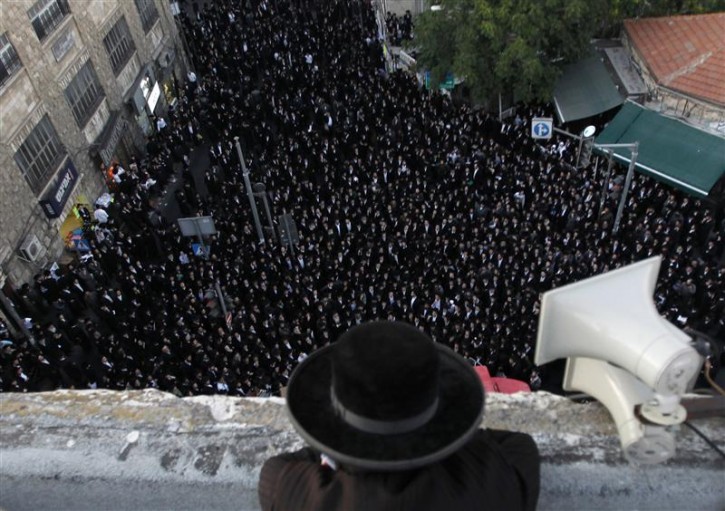 An Ultra-Orthodox Jewish man stands on a roof overlooking a protest by hundreds of ultra-Orthodox Jews in Jerusalem's Mea Shearim neighbourhood August 11, 2011. Hundreds of religious Jews protested against the Jerusalem municipality, which has organised outdoor summer events, some of which coincide with the Sabbath and will occur on roads near religious neighbourhoods. REUTERS/Baz Ratner