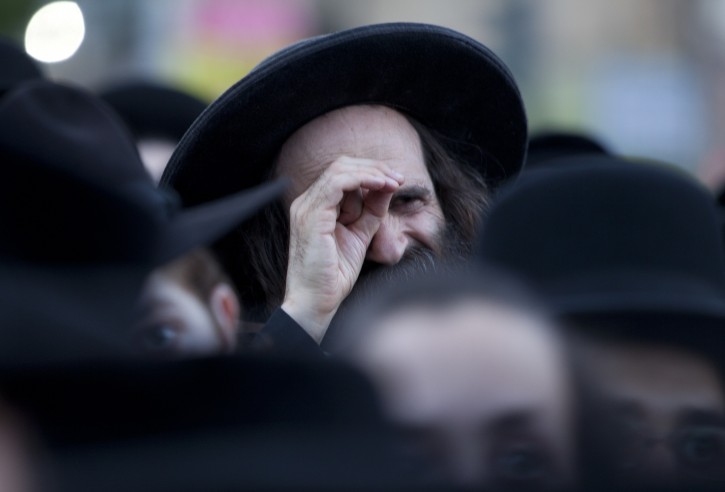 An ultra-Orthodox Jewish man looks on as they gather at the Sabbath Square in the Mea Shearim neighborhood in Jerusalem on 11 August 2011 protesting against social events planned for the summer by the Jerusalem municipality, which the religious community claims will break the Sabbath laws of Judaism, and corrupt religious people.  EPA/JIM HOLLANDER