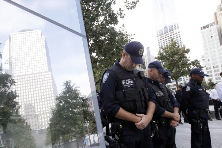 Port authority police officers observe a moment of silence at the National September 11 Memorial during a ceremony marking the 10th anniversary of the attacks on the World Trade Center Sunday, Sept. 11, 2011, at the World Trade Center site in New York. (AP Photo/Mary Altaffer)