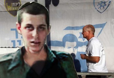 In this file photo, Noam Shalit (R), the father of abducted Israeli soldier Gilad Shalit, walks past a cut out of his son in a soldier's uniform (L), and a large banner at the protest ten  nearby the Jerusalem residence of Israeli Prime Minister Benjamin Netanyahu, on 25 June 2011, on the fifth anniversary of the cross border raid in which Gilad Shalit was captured by Hamas militants. EPA/JIM HOLLANDER