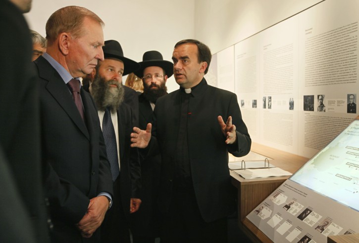 French Catholic Priest Patrick Desbois, right, presenting his exhibition 'Shoah by Bullets: Mass shootings of Jews in Ukraine 1941-1944' to former Ukrainian President Leonid Kuchma, left, in Kiev, Ukraine,  Thursday, Sept. 8, 2011. An exhibition devoted to the Nazi massacre of 1.4 million Jews in Soviet Ukraine during the Holocaust has opened in Kiev. The exhibit is based on the work of French Catholic Priest Patrick Desbois who has been canvassing the towns and villages of Ukraine to search for Jewish mass graves and interview the elderly witnesses to the Holocaust.  (AP Photo/Efrem Lukatsky)