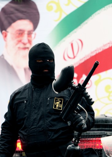 A Member of Iranian paramilitary Basij (volunteer) forces stands in front of a poster of Iranian supreme leader Ayatollah Khamenei during a parade in front the former US embassy in Tehran, Iran, 25 November 2011. Commander of Iran's Basij (volunteer) force Brigadier General Mohammad Reza Naqdi said that the volunteer forces are ready to respond any treats by Israel. He added that Basij fully prepared to defend Iran against enemies' treats.  EPA/ABEDIN TAHERKENAREH