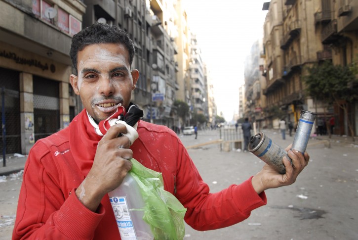 An Egyptian protester holds canisters during the clashes with the Egyptian riot police, unseen, in Tahrir square, Cairo, Egypt, Monday, Nov. 21, 2011. Police are clashing for a third day in Cairo's central Tahrir Square with stone-throwing protesters demanding the country's military rulers quickly transfer power to a civilian government. (AP Photo/Mohammed Abu Zaid)