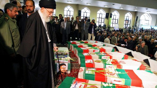 In this photo released by an official website of the Iranian supreme leader's office, supreme leader Ayatollah Ali Khamenei, prays, at the flag draped coffins of a group of members of Revolutionary Guard, in their funeral ceremony, on Monday Nov. 14, 2011, who were killed in an explosion at an ammunition depot west of Tehran on Saturday. (AP / Office of the Supreme Leader)