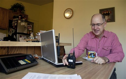 Scanner hobbyist Rick Hansen holds his scanner/Ham radio device at his home Saturday, Nov. 19, 2011, in Silver Spring, Md. In an effort to restrict access to their internal communications police departments around the nation are moving to encrypt them. (AP Photo/Carolyn Kaster)