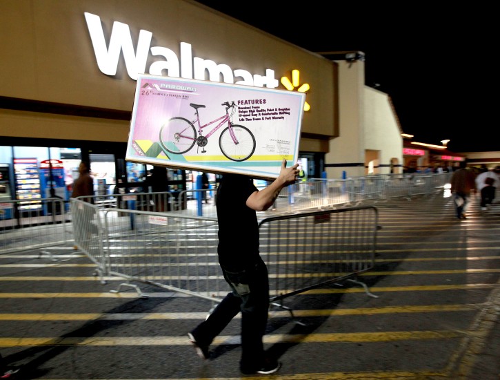 A shopper walks to his car after purchasing a bike at Walmart in Butler Plaza on Thursday, Nov. 24, 2011, in Gainesville, Fla. Walmart opened stores on Thursday. (AP Photo/Matt Stamey, The Gainesville Sun)