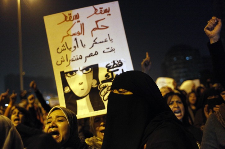 Egyptian women angered by the recent violence used against them in clashes between army soldiers and protesters, one carrying a poster that reads in Arabic "Down with military rule, Military are liars and We will cut your hand" chant anti military slogans during rally that ended in Tahrir Square, Cairo, Egypt Tuesday, Dec. 20, 2011. Egypt's ruling generals are coming under mounting criticism at home and abroad for the military's use of excessive force against unarmed protesters, including women, as they try to crush the pro-democracy movement calling for their ouster. (AP Photo/Nasser Nasser)