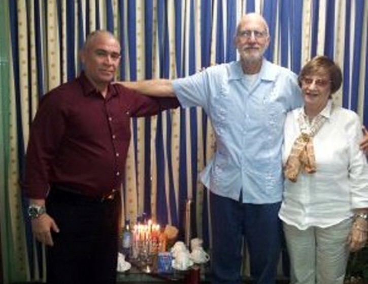 In this photo taken Monday Dec. 26, 2011 and provided to the Associated Press by Adela Dworin, American government contractor Alan Gross, center, poses for a photo with Cuban Jewish leaders Adela Dworin, right, and David Prinstein at the Finlay military hospital in Havana, Cuba, during a visit with Gross to celebrate the Jewish holiday Hanukkah.  Gross, sentenced to 15 years in jail earlier this year, was accused of working for an USAID program aimed at bringing about regime change on the island. He was not included in a massive prisoner amnesty announced by President Raul Castro last week.(AP Photo)