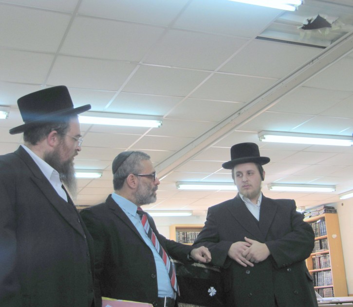 Prominent International lawyer Mordechai Tzivin speaks to Ezriel Weisman on the left  and Aron Fink on the right