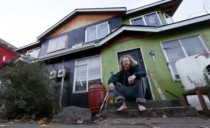 In this photo shot Monday, Dec. 5, 2011, a Occupy Seattle protester who goes by the name "Mufasa" sits on the steps of a formerly boarded-up duplex members of the group have taken over in Seattle. Following tactics by Occupy Wall Street demonstrators in Seattle, Portland and Oakland, protesters across the country are staging "Occupy Homes" actions nationally to try to stop foreclosures. (AP Photo/Elaine Thompson)