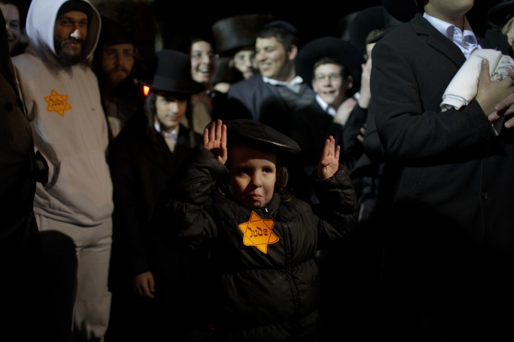 An Orthodox Jewish child, wearing a Star of David patch similar to those the Nazis forced Jews to wear, attends a rally in Jerusalem's Mea Shearim neighborhood, Saturday, Dec. 31, 2011. Thousands of ultra-Orthodox Jews gathered to rally for the right to protect their way of life. (AP Photo/Bernat Armangue)