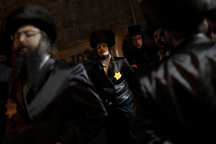 Orthodox Jewish men, wearing a Star of David patch similar to those the Nazis forced Jews to wear, attend a rally in Jerusalem's Mea Shearim neighborhood, Saturday, Dec. 31, 2011. Thousands of ultra-Orthodox Jews gathered to rally for the right to protect their way of life. (AP Photo/Bernat Armangue)